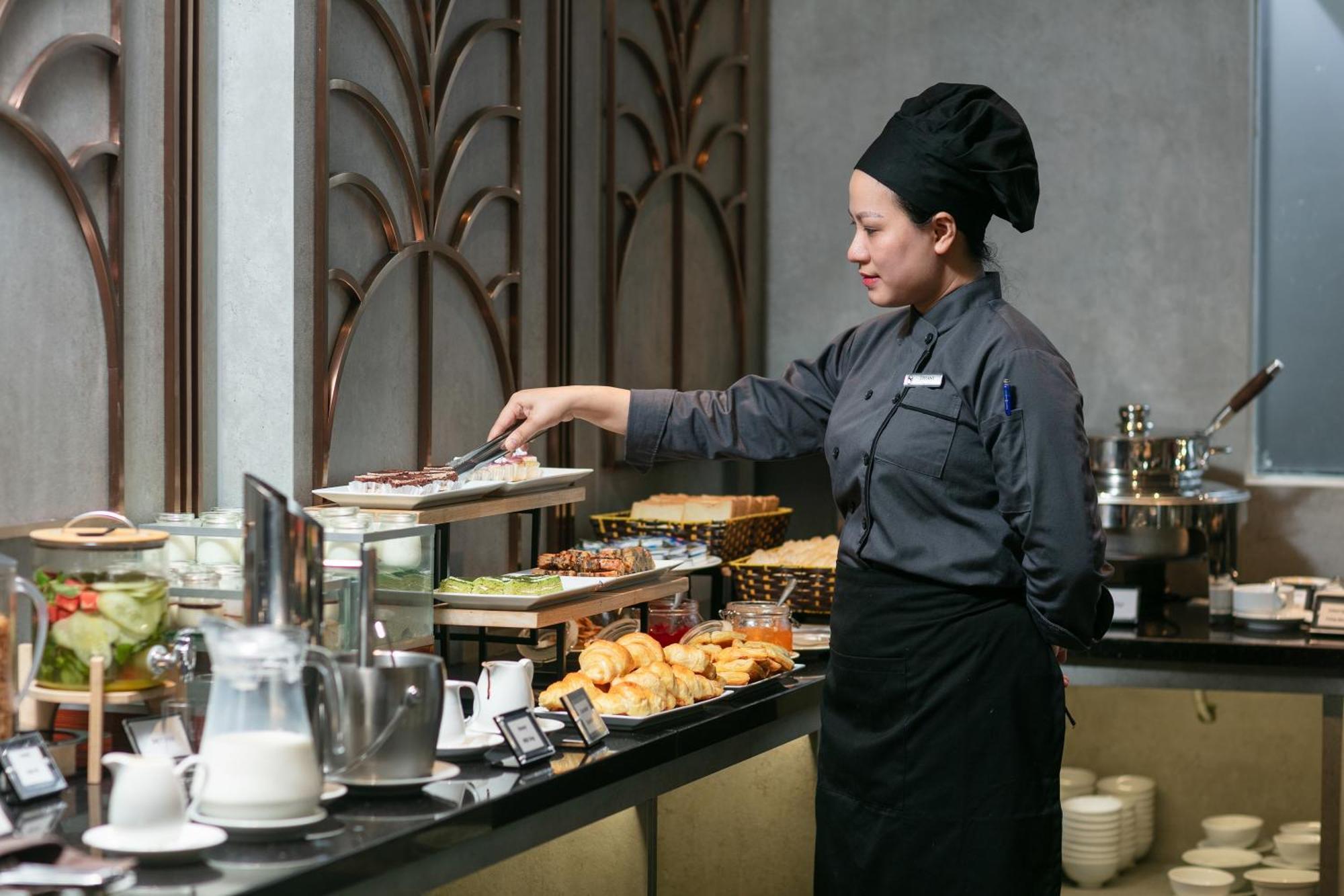 May De Ville Crown Hotel Hanoi Exteriör bild A cook at work